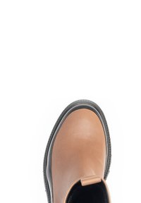 Botte en cuir marron avec un bout rond, une semelle texturée, des panneaux latéraux élastiques et un design profil bas avec des accents noirs.