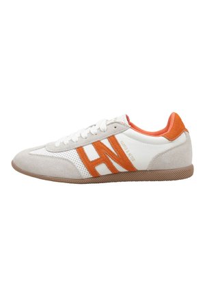 Zapatilla blanca y beige con franjas naranjas de ante con el logotipo "HN", forro interior naranja, cordones blancos y suela de goma marrón.