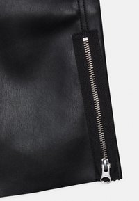 Černá koženka s hladkým povrchem, na boku se stříbrným zipem, doplněná kontrastní černou látkovou panelem.