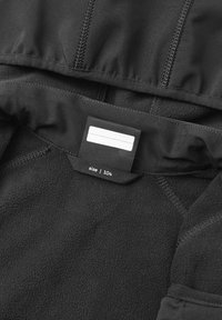 Black fleece hoodie interior with a smooth texture, featuring a size tag attached. Seam details are visible along the edges.