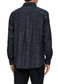 Donkerblauwe langek mouwen shirt met een textuurpatroon. Voorzien van een button-down kraag, verstelbare manchetten en een recht rugpand ontwerp.