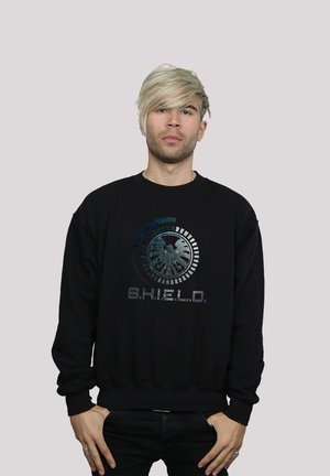 Svart hettegenser med grafisk trykk av et logo med teksten "S.H.I.E.L.D." i metalliske farger. Ribbestrikkede mansjetter og midjebånd.