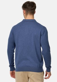Granatowy sweter z długim rękawem, z prążkowanymi mankietami i dołem, z teksturowanym wzorem dzianiny. Prosty, klasyczny design.