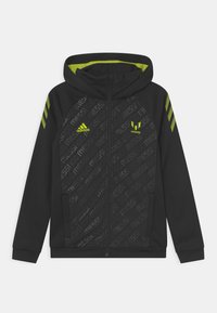 Felpa nera con zip caratterizzata da un design testurizzato con branding "Messi", dettagli verde lime e tre strisce sulle maniche.