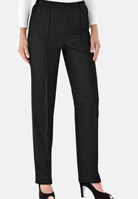 Zwarte pantalon van een gladde, gestructureerde stof, met een tailleband en een recht model, getoond met zwarte open-sandaletten.