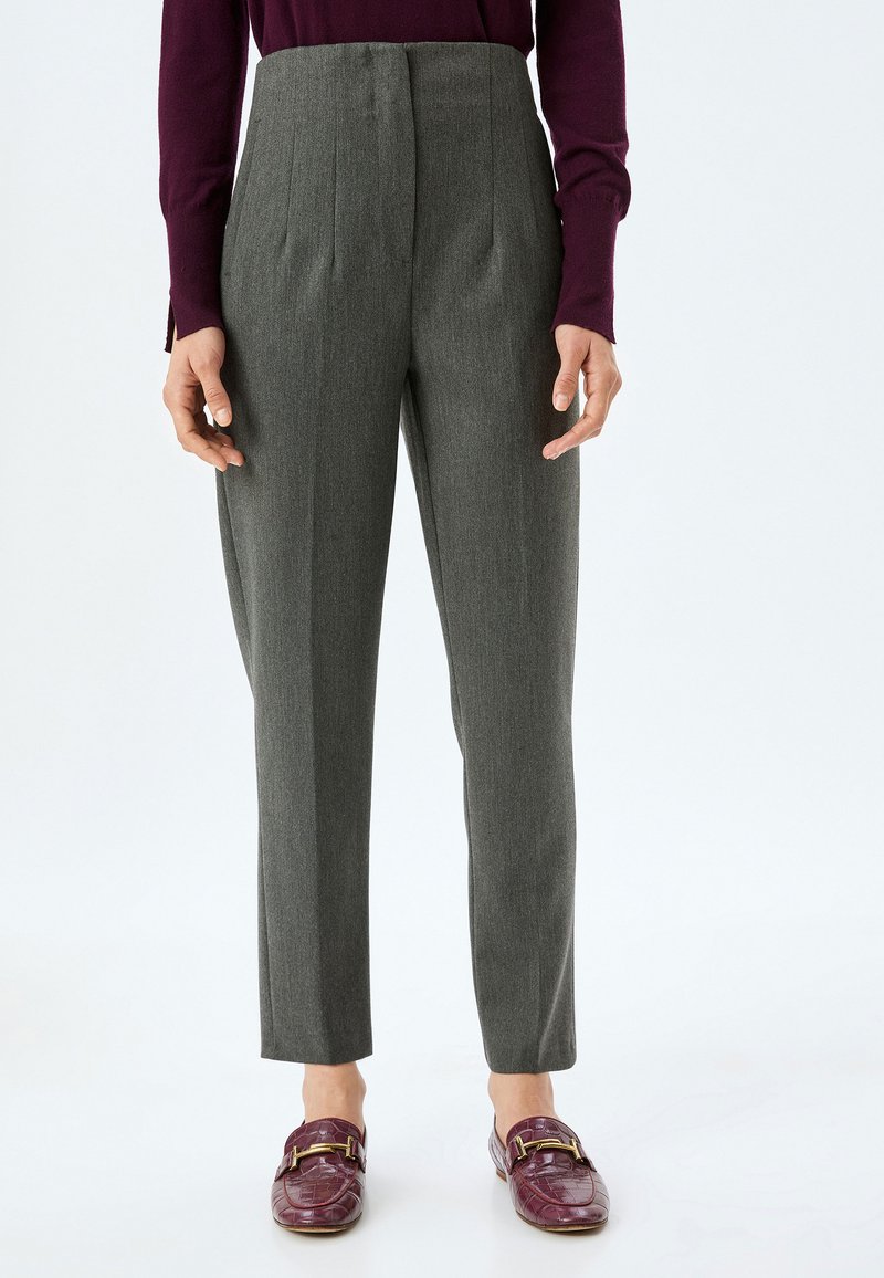 Gray tailored trousers with a high waist, pleats, and a slim fit. Paired with burgundy loafers featuring a gold accent.