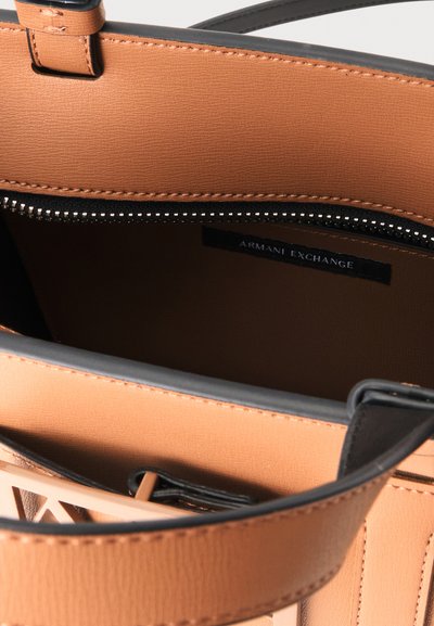 Interior de bolso de cuero marrón con bolsillo negro con cremallera y etiqueta visible "Armani Exchange".