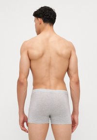 Szürke pamut boxeralsó, középhosszú, puha tapintású, rugalmas derékpánttal, minimalista dizájnnal, hátulról nézve, sima háttér előtt.