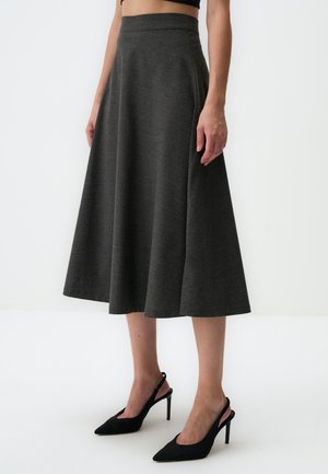 Gray, flared midi skirt in a textured fabric, with a high waistband and a smooth finish. Paired with black, pointed-toe heels.