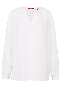 Blouse blanche à manches longues avec un col en V et un tissu texturé. Présente des coutures décoratives et une coupe ample. Matière légère en coton.