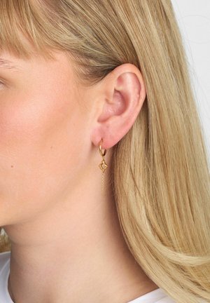 Cercel tip cerc din aur, cu un charm în formă de diamant și o picătură cu lanț. Textură netedă, finisaj strălucitor și detalii complexe în design.