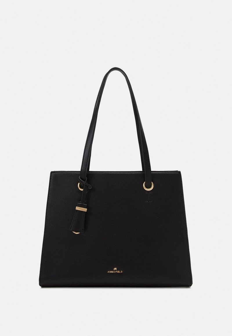 Sac à main rectangulaire noir avec deux fines poignées, détails métalliques dorés et petit logo "Anna Field" au centre avant.