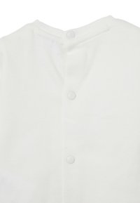 Weißer Baumwoll-Bodysuit mit rundem Ausschnitt, ausgestattet mit fünf weißen Druckknöpfen auf der Rückseite für ein einfaches Ankleiden. Glatte Textur ohne Muster.