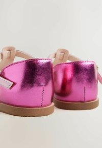 Roze metallic schoenen met een gladde, reflecterende afwerking en zachte beige accenten; voorzien van een bandje en een gestructureerde bruine zool.