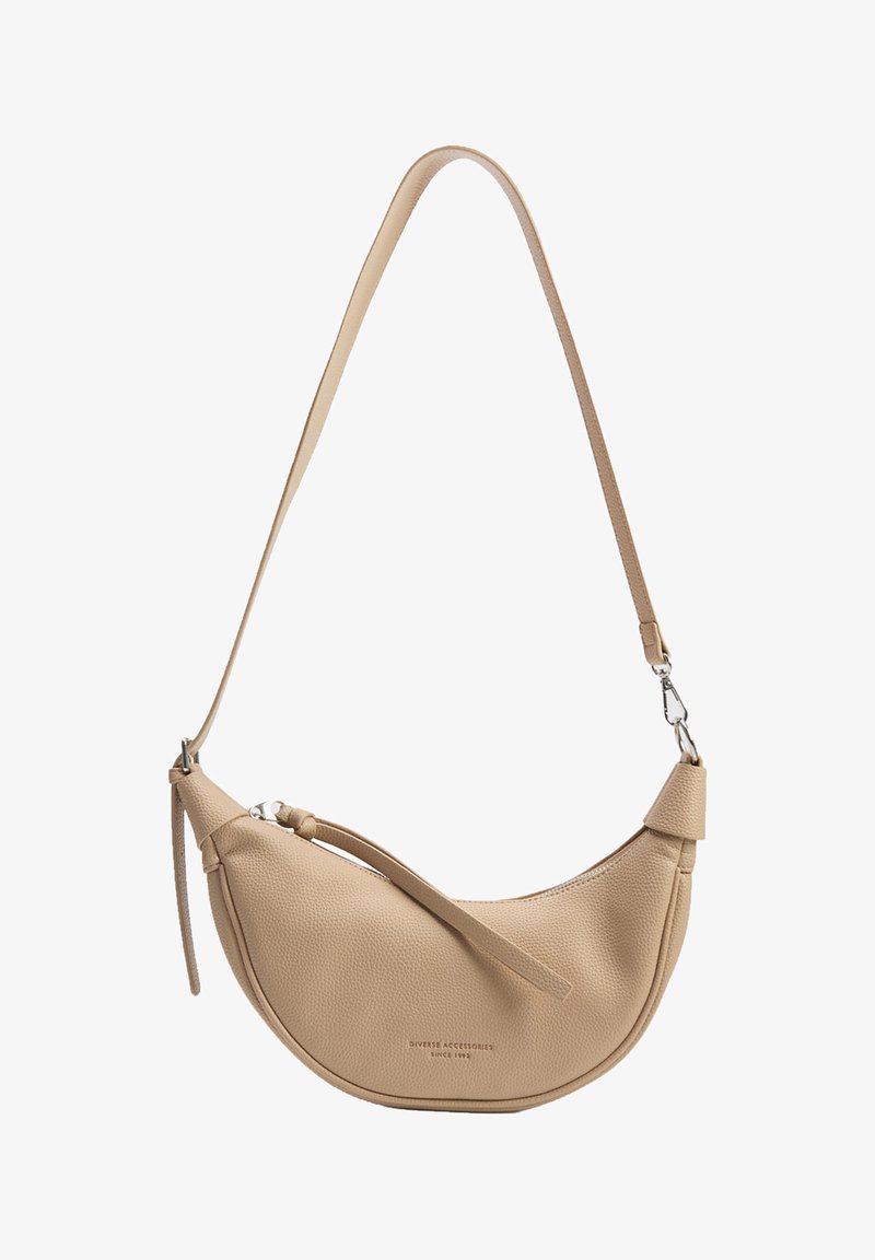 Beżowa skórzana torebka w kształcie łuku, z fakturowanym wykończeniem i długim regulowanym paskiem. Posiada zamek błyskawiczny oraz subtelną markę.