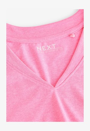 Różowy t-shirt z dekoltem w serek i krótkim rękawem typu casp, wykonany z miękkiej tkaniny. Posiada prosty dekolt oraz widoczne szwy z metką wewnątrz.