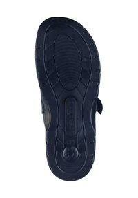 Black rubber sole with textured grip, unique tread pattern and raised accents, and velcro closure on a dark fabric upper.