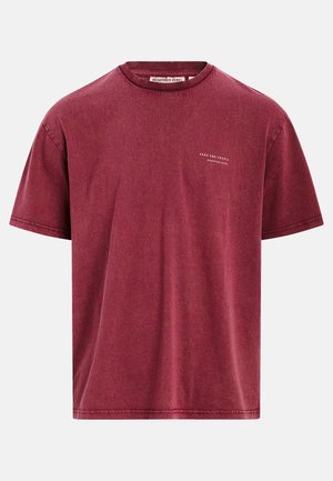 T-shirt bordeaux à manches courtes avec col rond et petit texte blanc sur la poitrine gauche indiquant « Take the Chance Redefined Rebel ».