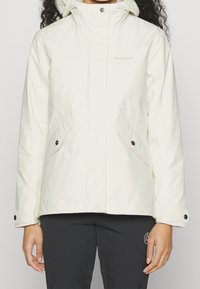 Chaqueta impermeable blanca con capucha, que presenta dos bolsillos frontales en ángulo y cierres de presión, textura lisa y una marca mínima en el pecho.