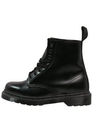 Bottine noire en cuir à lacets, avec semelle rembourrée et languette à l'arrière, vue de côté extérieur sur fond blanc.