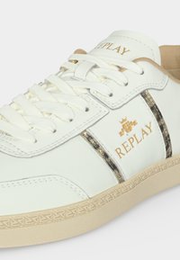 Λευκό sneaker Replay με μπεζ σόλα, κορδόνια και λεπτομέρειες λογότυπου, με υφασμάτινες ρίγες στα πλάγια.