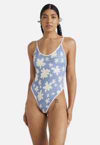 Eén-delig zwemoutfit in lichtblauw met witte bloempatronen, met dunne banden en een hoog uitgesneden beenontwerp. Gemaakt van rekbare stof.