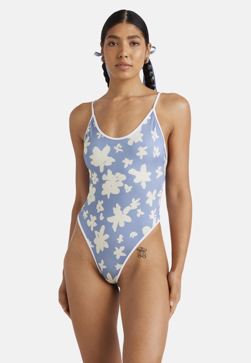 Costume intero di colore azzurro chiaro con motivo floreale bianco, dotato di spalline sottili e design con gamba alta. Realizzato in tessuto elastico.