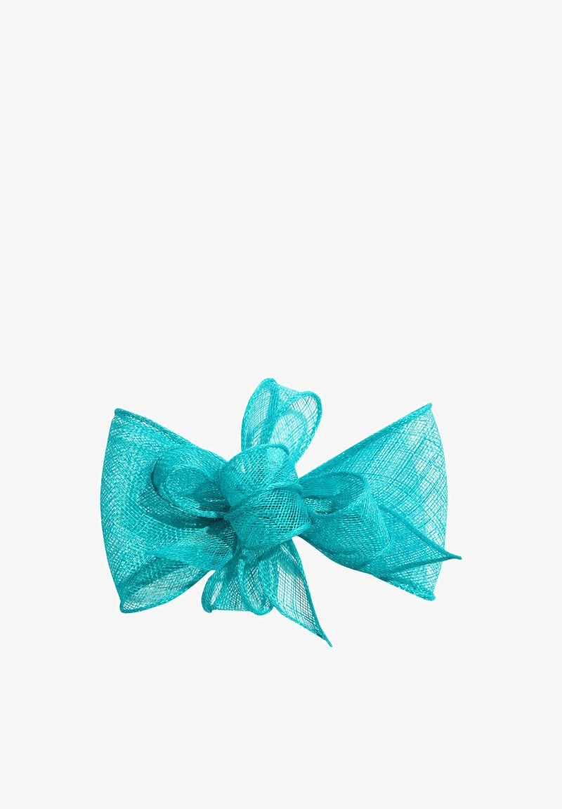 Nœud en maille turquoise avec plusieurs boucles et extrémités larges, translucide et texturé, posé sur un fond blanc.