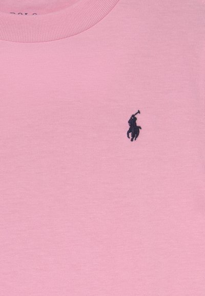 Polo shirt in soft pink cotton, featuring a round neckline and a small navy blue embroidered logo of a polo player on the left chest.