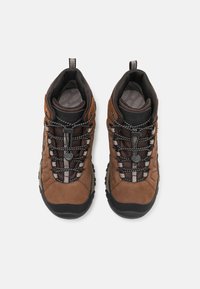 Braune Wildleder-Wanderschuhe mit schwarzen Gummisohlen. Zu den Merkmalen gehören Netzpaneele, reflektierende Schnürsenkel und gepolsterte Kragen für zusätzlichen Komfort.