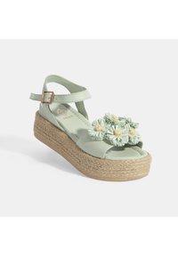 Grüne Leder-Plateausandalen mit einer juteummantelten Sohle, ausgestattet mit drei Blumenakzenten und einem Schnallenriemen für einen sicheren Halt.