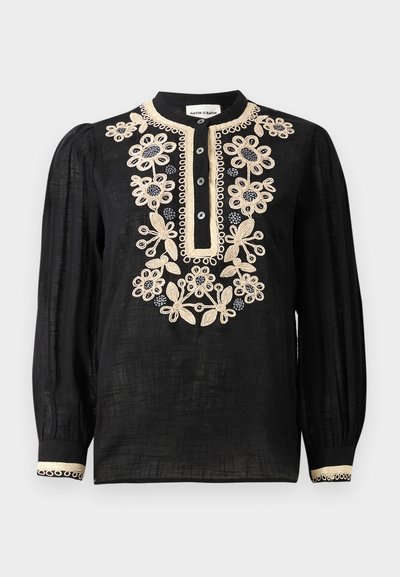 Blusa nera con maniche lunghe, con ricami floreali crema dettagliati, una pattina con bottoni e polsini decorativi. Realizzata in tessuto leggero.