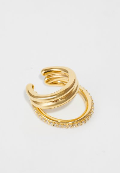 Guldfarvede ringe med et glat, snoet design og et andet bånd prydet med klare sten langs kanten.