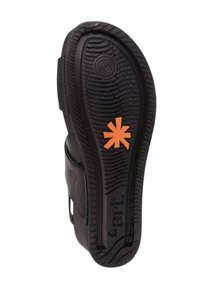 Calzado negro con una suela de goma texturizada que presenta un patrón circular y un logotipo de estrella naranja en la parte inferior.