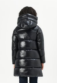 Zwarte pufferjas met een glanzende afwerking, capuchon en horizontale quilted structuur. De jas heeft een middellange snit en flexibele manchetten.