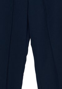 Pantalon sur mesure bleu marine foncé avec des plis visibles le long des jambes, montrés du milieu de la cuisse jusqu'à la cheville.