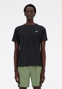 Black short-sleeve athletic shirt with mesh texture and New Balance logo, paired with green shorts. Simple, athletic fit design.