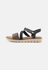 Sandales noires à plusieurs lanières avec un motif tissé et une semelle beige rembourrée. Équipées de lanières ajustables et d'un accent décoratif en or.
