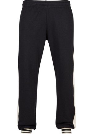 Zwarte joggingbroek met een ontspannen pasvorm, voorzien van crèmekleurige zijkanten en ribgebreide boorden. Gemaakt van zachte stof voor comfort en duurzaamheid.