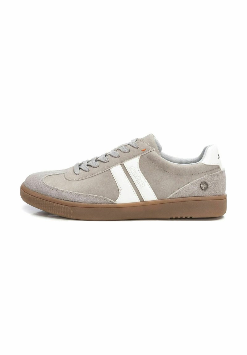 Zapatilla de ante gris claro con acentos de cuero blanco, cordones planos, suela redonda de goma marrón y detalle de marca en el lateral.