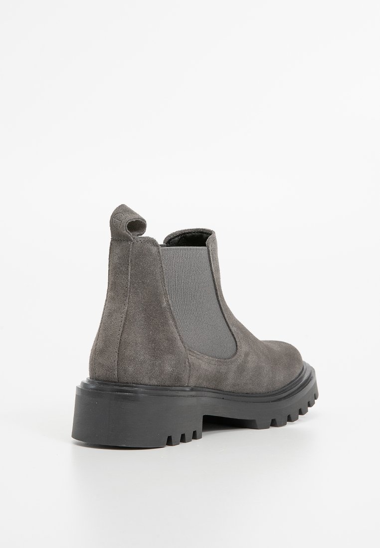 Stivaletto in suede grigio con punta rotonda, pannelli laterali elastici, un occhiello per la presa e una suola in gomma spessa con battistrada profondo per una maggiore aderenza.