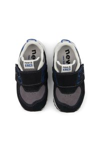 Baskets pour enfants noires et grises avec des accents bleus. Dotées d'une sangle Velcro, de matériaux en daim et en maille, d'une pointe ronde et de semelles blanches.