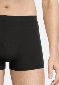Black cotton boxer briefs featuring a snug fit, smooth texture, and flat seams for comfort. Designed with a short leg cut and no visible branding.
