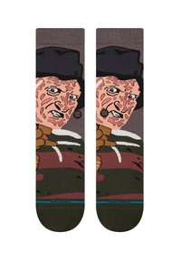 Calcetines hasta la rodilla con un diseño gráfico de un personaje con un sombrero y garras, predominantemente en colores marrón, rosa y verde.