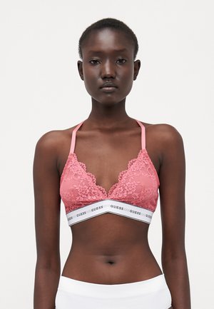 Rosa blonde bralette med blomsterdesign, justerbare stropper og et merket hvitt elastisk bånd. Har en trekantet form og en myk tekstur.