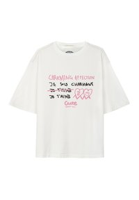 Biała bawełniana koszulka z krótkim rękawem, z zabawnym napisem w różowym i czarnym kolorze, z grafikami serc oraz luźnym krojem.