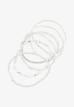 Hõbedased mitme niidi käevõrud, mis sisaldavad erinevaid helme kujundeid, sealhulgas ümmarguseid, kuhexagonaalseid ja ristkülikukujulisi, ning neil on poleeritud tekstuur.