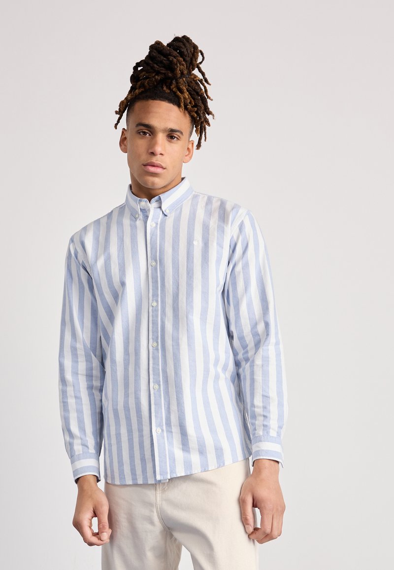 Camisa de botonadura con rayas verticales azules y blancas, mangas largas y cuello. El material parece ligero y texturizado.