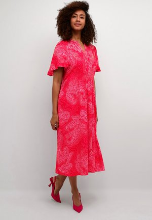 Robe paisley rose avec des manches courtes et volantes et un décolleté en V. Le design au genou présente des motifs blancs sur un fond lumineux.