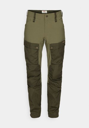 Grüne Outdoor-Hosen aus strapazierfähigem Material, mit cargo-Taschen, einem taillierten Oberteil und Strukturvariationen an den Unterschenkeln.